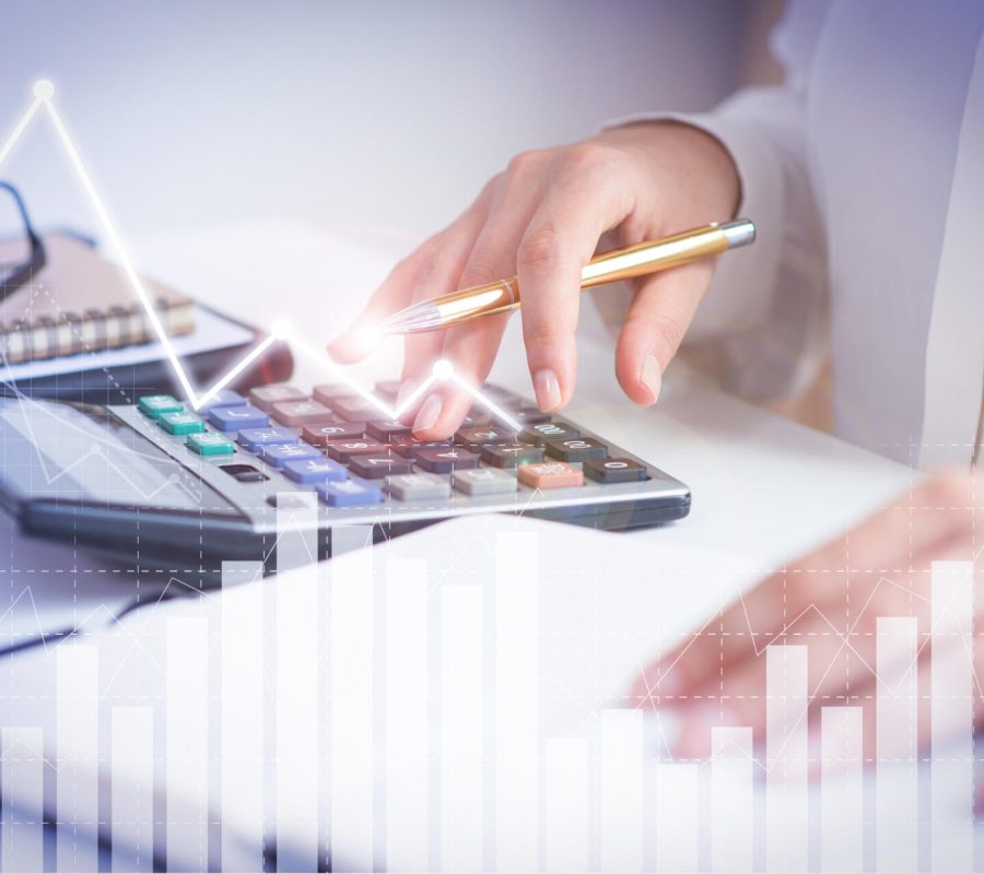 Accountant calculating profit with financial analysis graphs. Notebook, glasses and calculator lying on desk. Accountancy concept. Cropped view.